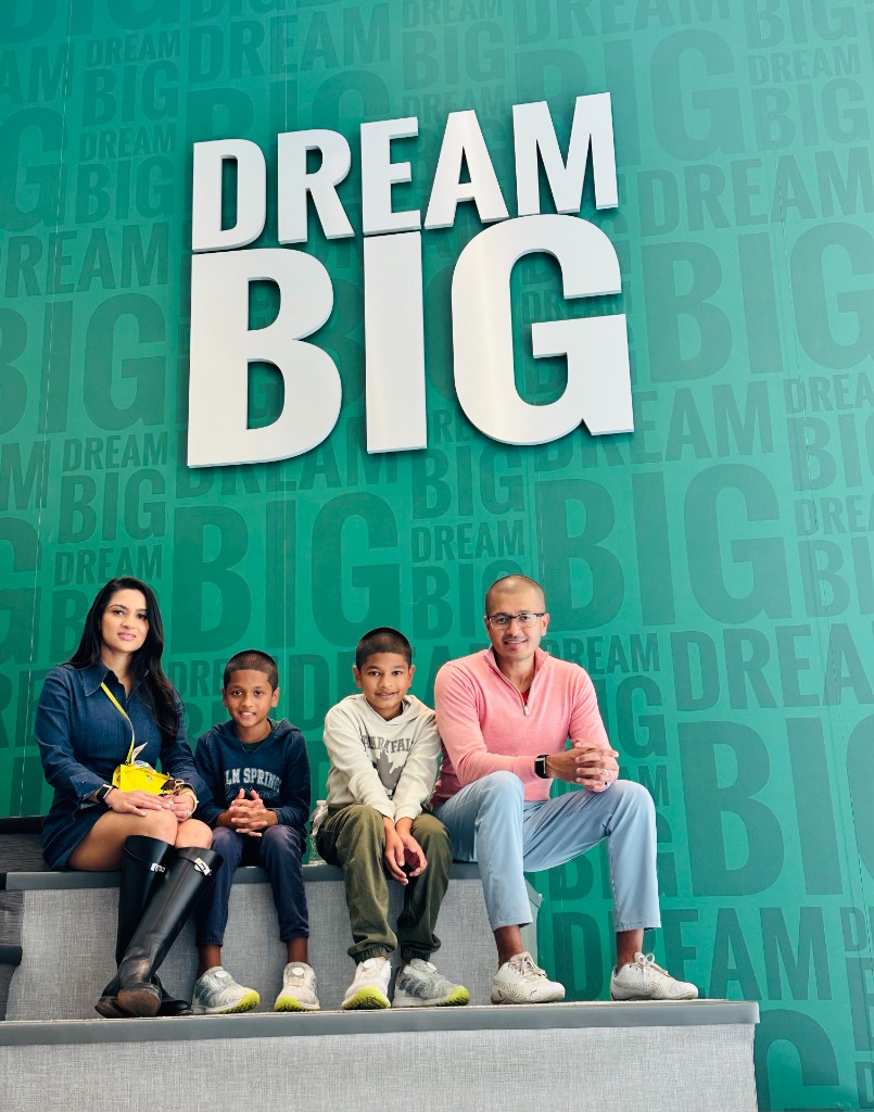 Nobel family sitting together in front of a Dream Big wall